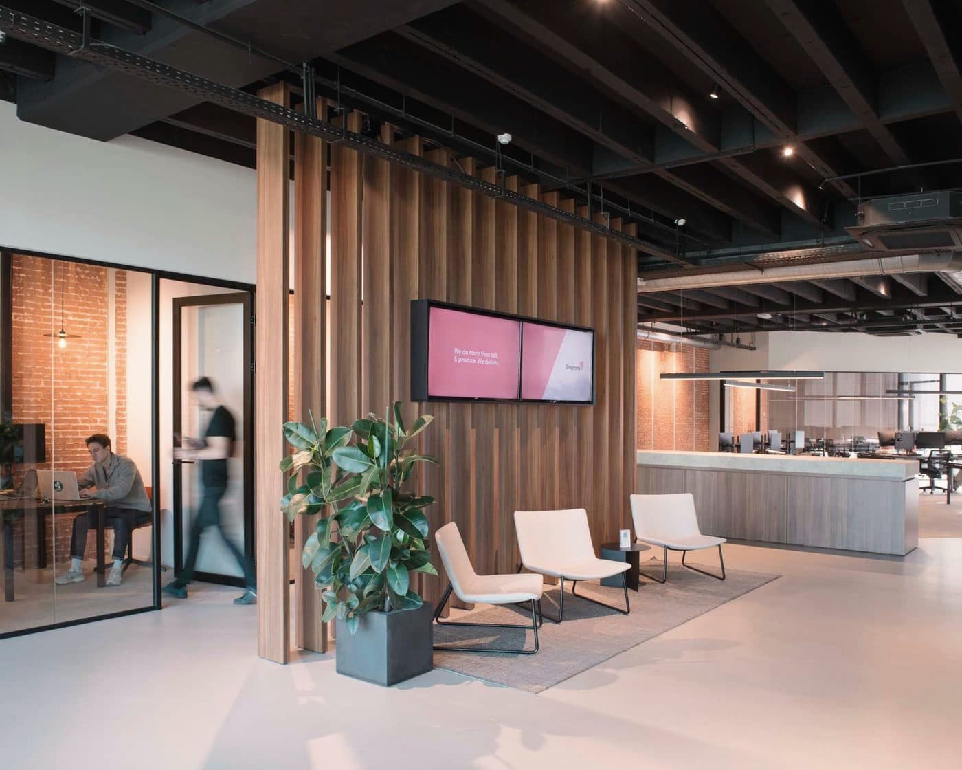 The reception of our office in Antwerp, with wooden slats and light armchairs